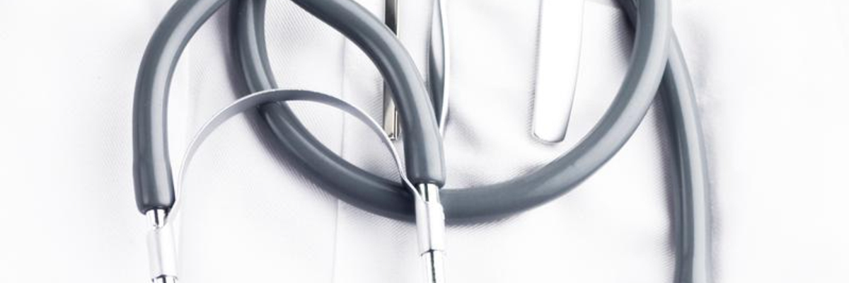 stethoscope, syringe and ballpoins on doctor's lab coat